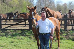 Jens Less mit Pferden vor dem Winterauslauf auf dem Pensionpferdebetrieb Less